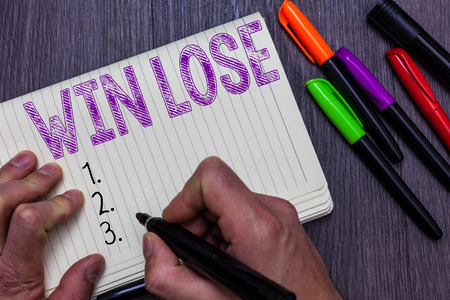Text sign showing Win Lose. Conceptual photo Compare possibilities what if everything goes well or wrong Man holding marker notebook paper communicating ideas Wooden backgroundの写真素材
