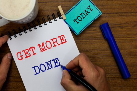 Writing note showing Get More Done. Business photo showcasing Checklist Organized Time Management Start Hardwork Act Man holding marker notebook clothespin reminder wooden table coffeeの写真素材