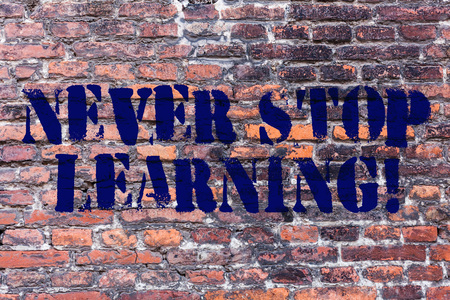 Handwriting text Never Stop Learning. Conceptual photo keep on studying gaining new knowledge or materials Brick Wall art like Graffiti motivational call written on the wallの写真素材