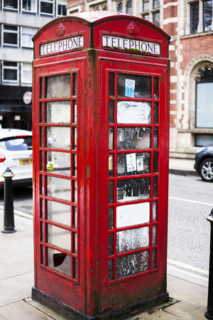 BIRMINGHAM, UK - March 2018 Rusty and Weathered Red Vintage Telephone Booth Standing in the City Street. Common London Public Payphone Icon Fixture on the Sidewalk of UK Urban Areasのeditorial素材