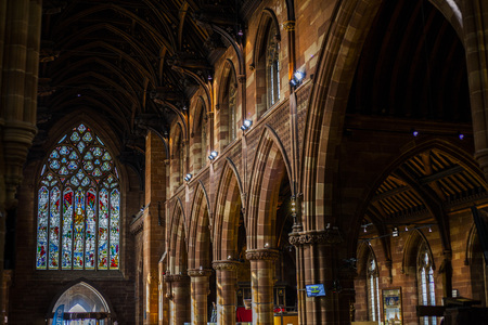 BIRMINGHAM, UK - March 2018 Stained Glass Window at the Far End Wall. Archs and Columns Dividing the Passageway from Main Hall. Intricate Wood Carvings on Ceiling Eaves and Pillarsのeditorial素材