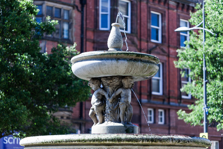 BIRMINGHAM, UK - March 2018 Fountain Made of Stone in St. Peters Garden in Wolverhampton England. Designed with Children Figures Supporting a Big Round Bowl on their Heads with Waterのeditorial素材