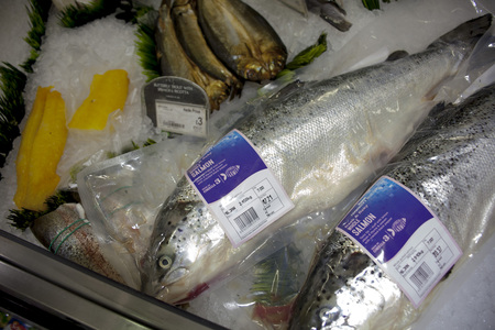 BIRMINGHAM, UK - March 2018 ASDA Two Big Fish Sealed in Transparent Plastic for Sale. Crushed Ice for Raw Seafood in the Wet Section of Supermarket. Labels and Price Tags for Each Productのeditorial素材