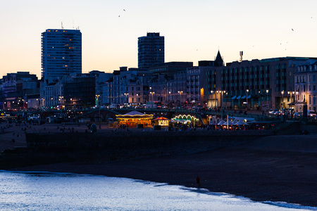 Brighton, UK - June 2018 Amusement and Fun Activity on Beachfront. High Rise Building and Structure Lining Up the Background. People Relaxing at Nightfall on Waterfront Vacant Lotのeditorial素材