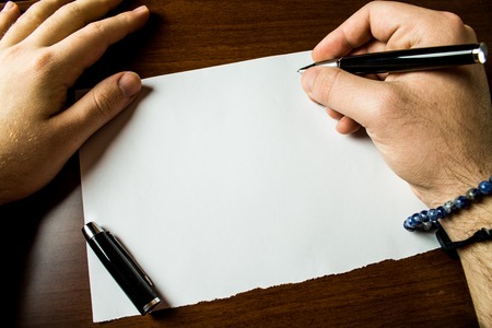Close up view male hands writing blank stationary paper pens wooden table Design business concept Empty copy space modern abstract backgroundの写真素材