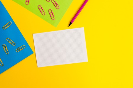 Blank paper sheets squared notebook pencil clips plain colored backgroundの写真素材
