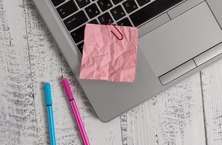 Trendy metallic laptop crushed colored paper note pens lying old wooden table