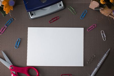 Scissors and writing equipments plus plain sheet above textured backdropの写真素材