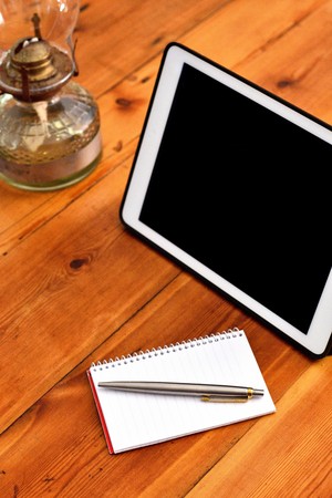 Writing equipments placed next to gadget plus a classic vintage lanternの写真素材