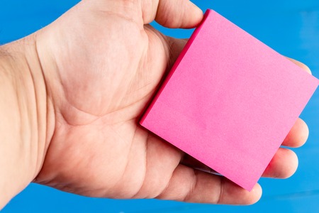 Front view colored background man hand palm holding sticky note. Things doの写真素材