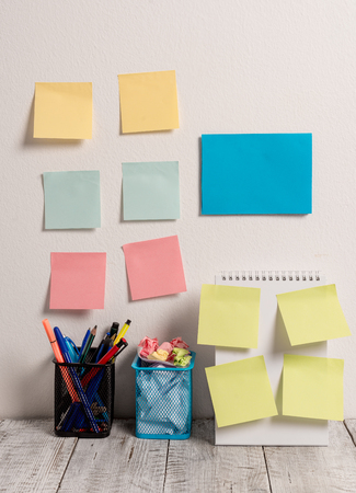 10 Sticky Notes Card on Wall Spiral Notebook 2 Pencil Pots on Work Deskの写真素材