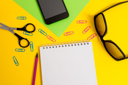 Sheet pencil clips smartphone scissors eyeglasses notepad color background