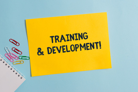Text sign showing Training And Development. Business photo showcasing Organize Additional Learning expedite Skills Plain cardboard and writing equipment placed above pastel colour backdropの写真素材