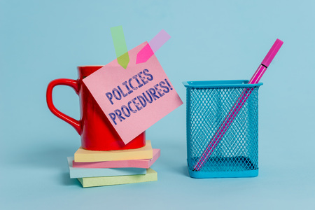 Handwriting text writing Policies Procedures. Conceptual photo Influence Major Decisions and Actions Rules Guidelines Cup note arrow banners stacked pads metal pen holder pastel backgroundの写真素材