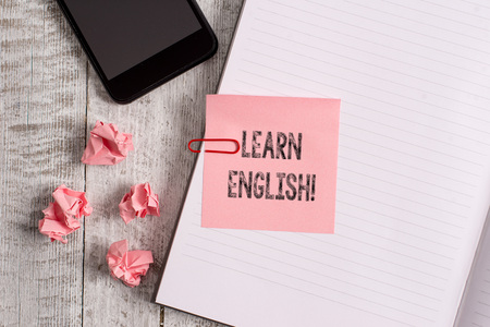 Conceptual hand writing showing Learn English. Concept meaning gain acquire knowledge in new language by study Notebook stationary placed above classic wooden backdropの写真素材