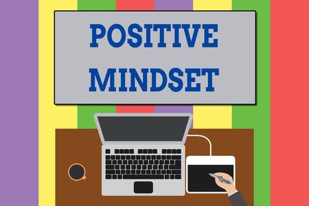Text sign showing Positive Mindset. Business photo text mental attitude in wich you expect favorable results Upper view laptop wooden desk worker drawing tablet coffee cup officeの写真素材