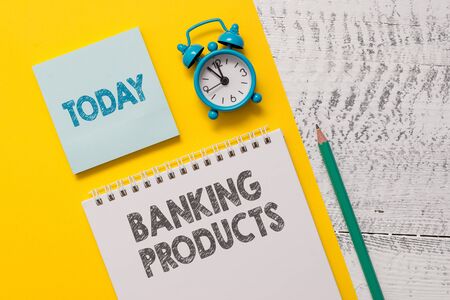 Text sign showing Banking Products. Business photo showcasing safe and convenient way or service to accumulate savings Spiral notepad paper sheet marker alarm clock retro wooden backgroundの写真素材