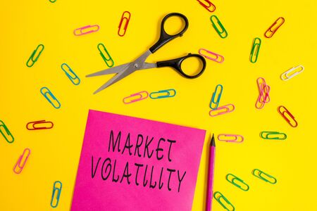 Handwriting text writing Market Volatility. Conceptual photo Underlying securities prices fluctuates Stability status Blank colored paper sheet scissors pencil clips light color backgroundの写真素材
