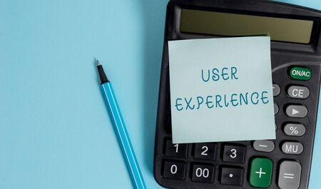 Conceptual hand writing showing User Experience. Concept meaning using website especially in terms how pleasing it is to use Electronic calculator sticky note marker colored backgroundの写真素材