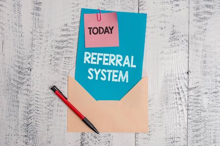 Text sign showing Referral System. Business photo text sending own patient to another physician for treatment Envelope blank sheet letter paper sticky note ballpoint wooden backgroundの写真素材