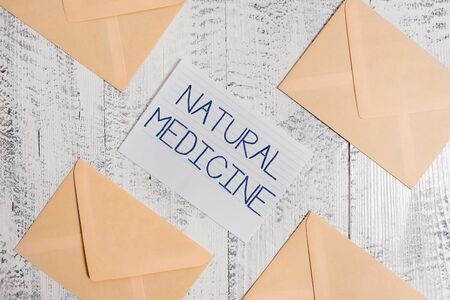 Text sign showing Natural Medicine. Business photo text any of various systems of healing or treating disease Four envelopes around ruled paper sheet old wooden vintage backgroundの写真素材