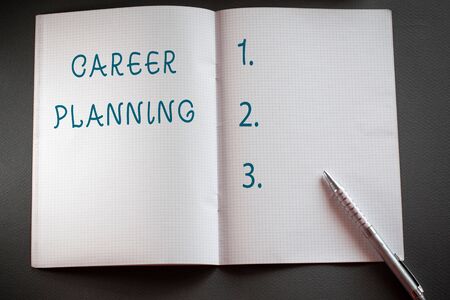 Word writing text Career Planning. Business photo showcasing Strategically plan your career goals and work success Checkered math book and classic silver pen placed above textured work deskの写真素材
