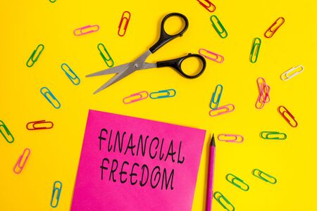 Handwriting text writing Financial Freedom. Conceptual photo Having money Free from worry when it comes to cash flow Blank colored paper sheet scissors pencil clips light color backgroundの写真素材