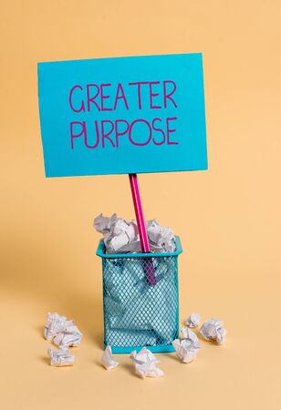 Word writing text Greater Purpose. Business photo showcasing Extend in average conforming the moral order of the universe crumpled paper trash and stationary with note paper placed in the trash canの写真素材
