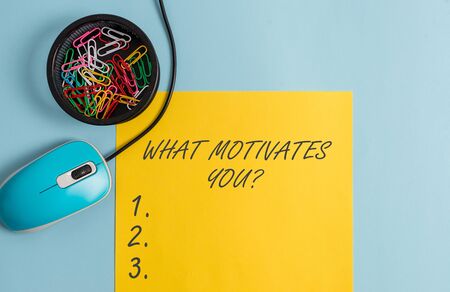 Conceptual hand writing showing What Motivates Youquestion. Concept meaning know reasons why you want to wake up each morning Notebook and stationary with gadgets above pastel backdropの写真素材