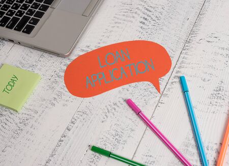 Conceptual hand writing showing Loan Application. Concept meaning Document that provides financial information about borrower Open laptop speech bubble ballpoints sticky notes wooden tableの写真素材