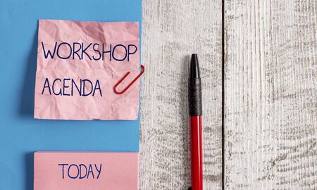 Handwriting text Workshop Agenda. Conceptual photo helps you to ensure that your place stays on schedule Wrinkle paper and cardboard plus stationary placed above wooden backgroundの写真素材