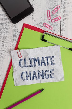 Handwriting text Climate Change. Conceptual photo Increase in global average temperature Weather transformation Clipboard paper sheet pencil smartphone note clips wooden retro backgroundの写真素材