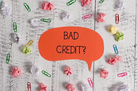 Writing note showing Bad Creditquestion. Business concept for inabilityof a demonstrating to repay a debt on time and in full Blank speech bubble paper balls clips wooden vintage rustic backgroundの写真素材