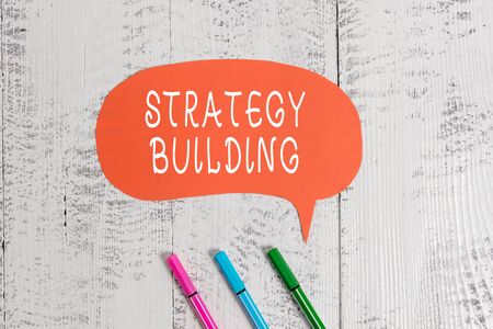 Handwriting text writing Strategy Building. Conceptual photo Leveraging Buying and acquiring others platforms Ballpoints blank colored speech bubble wooden rustic vintage backgroundの写真素材
