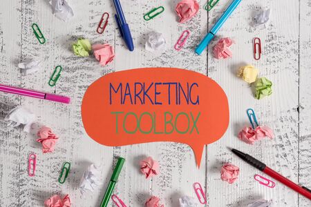 Handwriting text Marketing Toolbox. Conceptual photo Means in promoting a product or services Automation Blank speech bubble pens clips crushed paper balls vintage retro tableの写真素材
