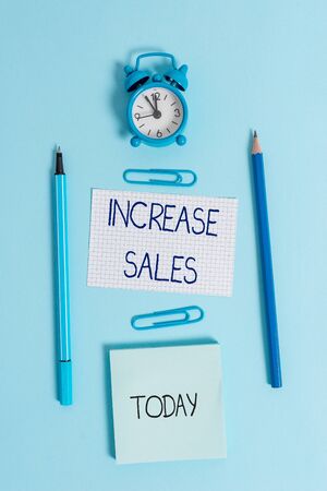 Writing note showing Increase Sales. Business concept for Boosting the product sold to customers Trade Growth Alarm clock squared paper sheet notepad markers colored backgroundの写真素材