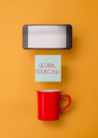 Word writing text Global Sourcing. Business photo showcasing practice of sourcing from the global market for goods Coffee cup colored sticky note electronic device yolk color backgroundの写真素材