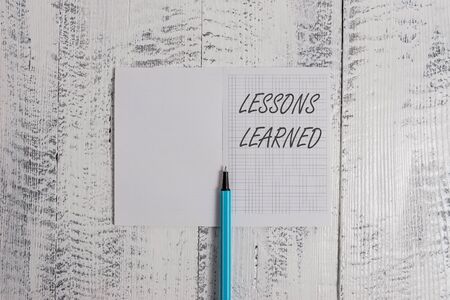 Conceptual hand writing showing Lessons Learned. Concept meaning information reflects positive and negative experiences Square notebook fine highlighter lying on wooden backgroundの写真素材