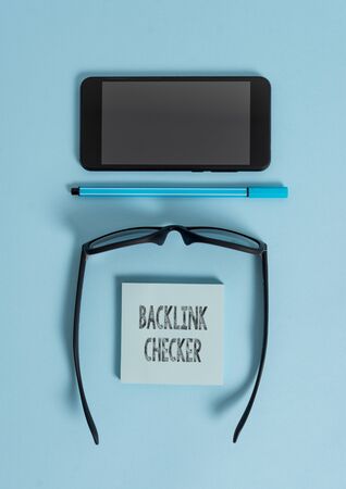 Conceptual hand writing showing Backlink Checker. Concept meaning Find your competitors most valuable ones and spot patterns Dark eyeglasses colored sticky note smartphone pastel backgroundの写真素材