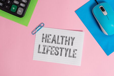 Conceptual hand writing showing Healthy Lifestyle. Concept meaning Live Healthy Engage in physical activity and exercise Wire electronic mouse calculator paper colored backgroundの写真素材