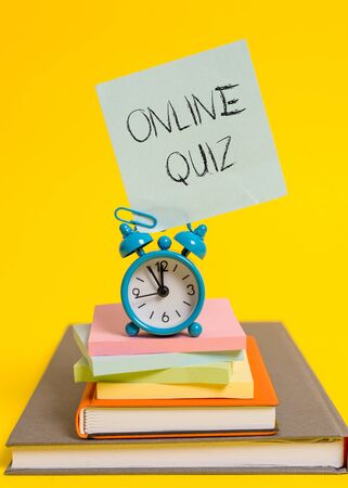 Handwriting text writing Online Quiz. Conceptual photo game or a mind sport that are published on the Internet Alarm clock note stacked notepads old books colored backgroundの写真素材