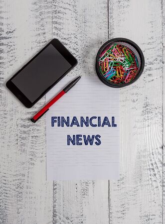 Conceptual hand writing showing Financial News. Concept meaning Investment banking Fund analysisagement Regulation and trading Smartphone paper sheet clips ballpoint wooden vintage backgroundの写真素材