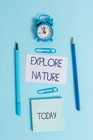 Writing note showing Explore Nature. Business concept for Discovering the countryside Enjoying the wildlife Travel Alarm clock squared paper sheet notepad markers colored backgroundの写真素材