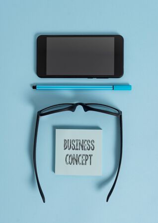 Conceptual hand writing showing Business Concept. Concept meaning new product approach to marketing or delivering it Dark eyeglasses colored sticky note smartphone pastel backgroundの写真素材