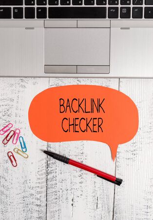 Text sign showing Backlink Checker. Business photo text Find your competitors most valuable ones and spot patterns Open laptop blank speech bubble pen ballpoint colored clips vintage woodenの写真素材