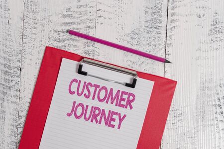 Handwriting text Customer Journey. Conceptual photo product of interaction between organization and customer Colored clipboard blank paper sheet pencil old wooden vintage backgroundの写真素材
