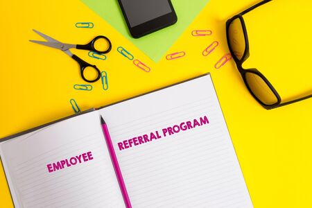 Word writing text Employee Referral Program. Business photo showcasing employees are rewarded for introducing recruits Sheet pencil clips smartphone scissors eyeglasses notepad color backgroundの写真素材