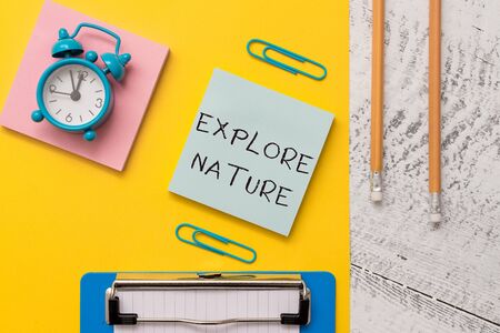 Writing note showing Explore Nature. Business concept for Discovering the countryside Enjoying the wildlife Travel Notepads paper sheet clipboard markers alarm clock wooden backgroundの写真素材