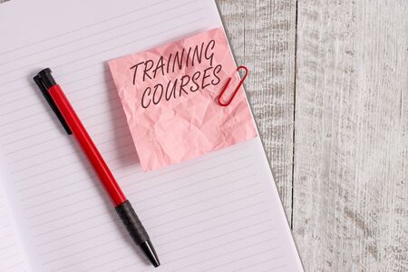 Text sign showing Training Courses. Business photo text is series of lessons or lectures teaching skills you need Wrinkle paper and notebook plus stationary placed above wooden backgroundの写真素材