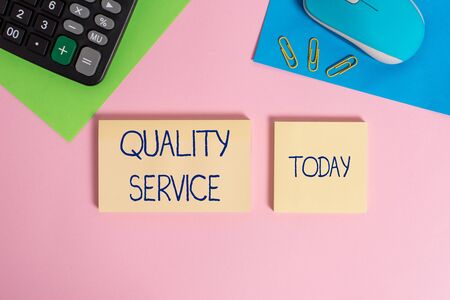 Writing note showing Quality Service. Business concept for how well delivered service conforms to clientexpectations Wire mouse portable calculator notepads paper sheets color backgroundの写真素材
